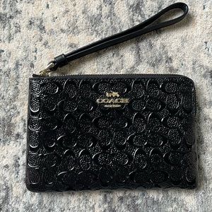 Coach wristlet in black paten leather with embossed logo